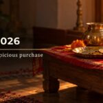 Dhanteras 2026 puja chowki with a brass kalash, gold coins, coriander seeds, a diya, marigolds & a new broom